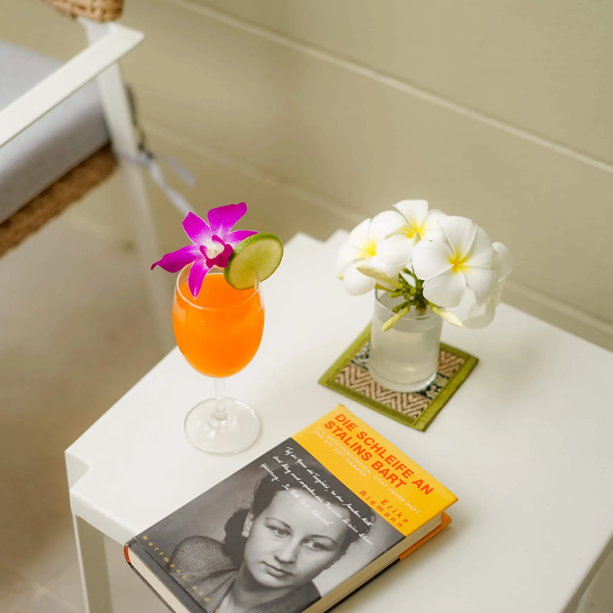 a glass of orange juice on the table with a book