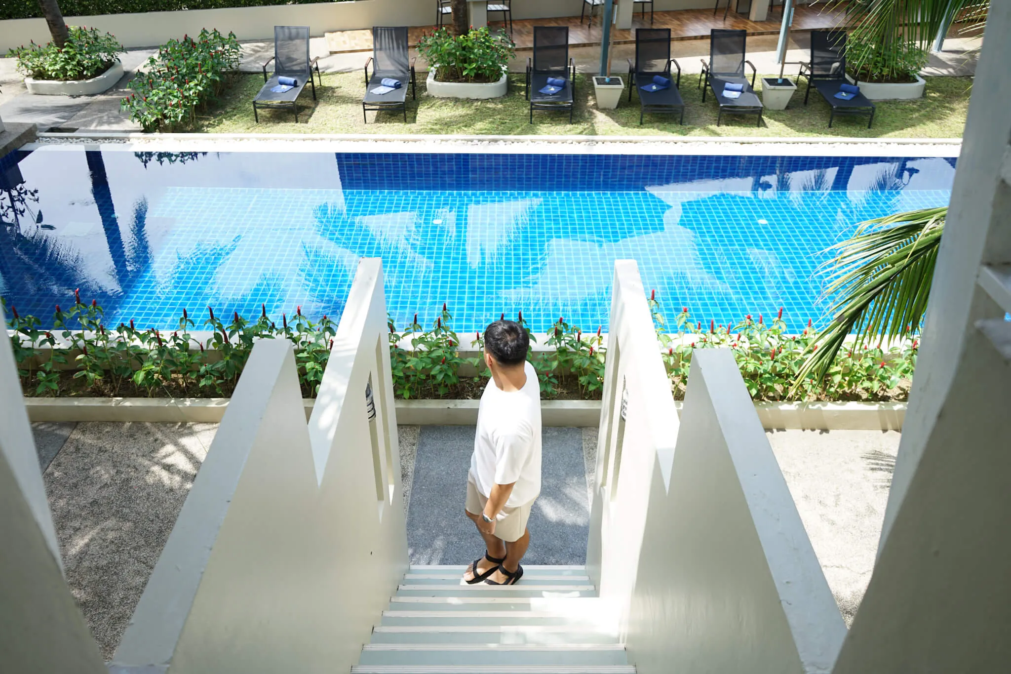 a man standing on a stair to the swimming pool